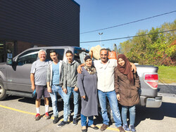 Jacques Laberge, porte-parole du Comité de soutien aux réfugiés syriens accueillis à Gatineau, et une bonne partie de la famille Aslan en octobre 2016, lors de leur arrivée au Canada. 
Photo : Courtoisie