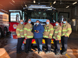 Michel Raymond et Michel Matthews, capitaine du Service de sécurité incendie de Gatineau, avec des pompiers de la Caserne de pompiers no 1 à Aylmer.
