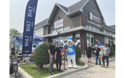 Le propriétaire et gérant du dépanneur Rapido, Marc-André Arvisais, et sa conjointe, Sandra Lopes, avec la mascotte Slush Puppie lors de la célébration des 40 ans de l’établissement, le 6 juin dernier. Crédit photo : Sophie Demers