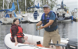 Les biologistes Marion Duflos et Pascal Samson à la marina d'Aylmer, ce dernier tenant un échantillon de myriophylle en épi, une espèce envahissante répandue dans tout le secteur. Crédit photo : Greg Newing