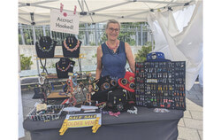 Ginette Bellehumeur, créatrice de bijoux derrière son kiosque à la Foire artisanale de la Pointe (13 juillet 2025). Photo : Mélissa Gélinas